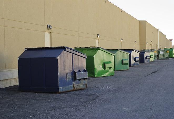 a fleet of red and blue construction dumpsters available for use in Bryceville FL